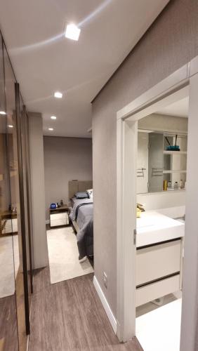 a bedroom with a bed and a sink and a mirror at Apartamento completo na praia brava in Itajaí