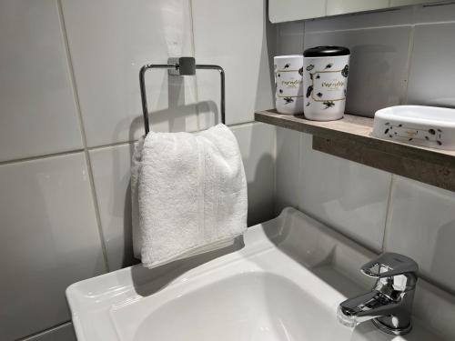 Cómodo departamento sector sur Iquique في إكيكي: بالوعة بيضاء في الحمام مع منشفة