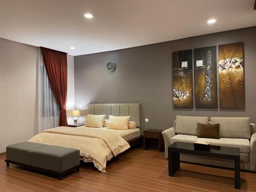 1 dormitorio con 1 cama, 1 sofá y 1 silla en Villa La Vimala en Gadok 1