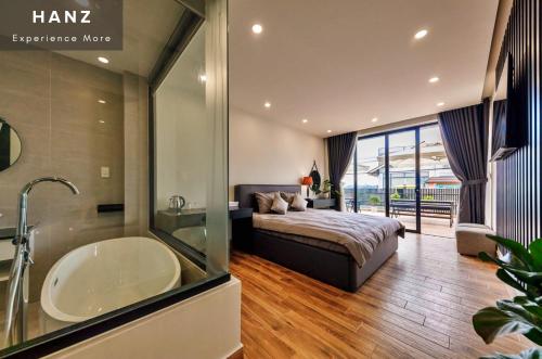 a bedroom with a bed and a tub and a sink at HANZ Premium Villa Pandora Dalat in Da Thien