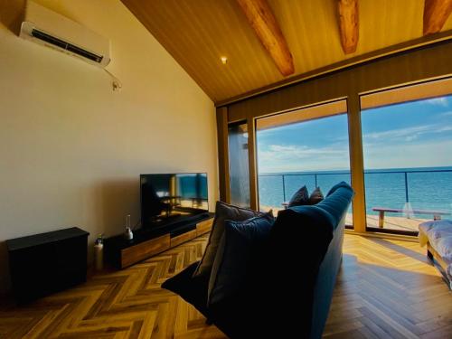 a living room with a couch and a tv and the ocean at AWAJI OCEAN BASE west coast in Tusi