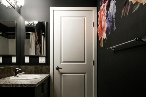 a bathroom with a white door and a sink at Entire Home Near Calgary, Canmore & Banff Rocky Mountain Gateway in Cochrane