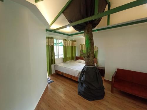 - une chambre avec un lit et un arbre dans un sac dans l'établissement SpiceBuds FarmStay - Ramakkalmedu, à Idukki