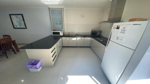 a kitchen with a refrigerator and a counter top at Unit 24 Seafront Estate in Jurien Bay