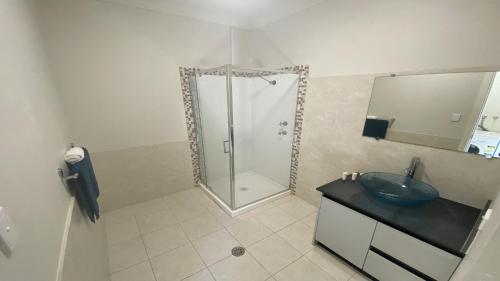 uma casa de banho com um lavatório e um chuveiro com um espelho. em Unit 58 Seafront Estate em Jurien Bay