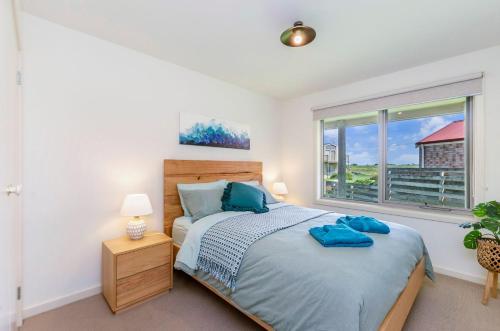 a bedroom with a bed and a window at Southern Waves in Port Fairy