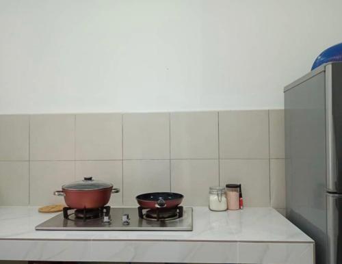 a kitchen with two pots and pans on a stove at Al-Amin Homestay, Jasin, Melaka in Jasin