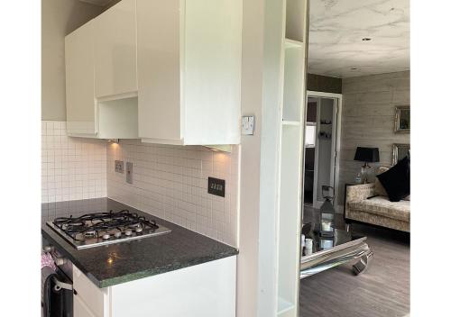 a kitchen with white cabinets and a stove top oven at Glasgow two bedroom Penthouse in Glasgow