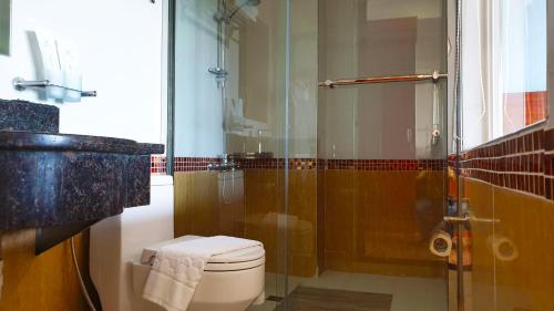 a bathroom with a toilet and a glass shower at 456 Hotel in Baguio