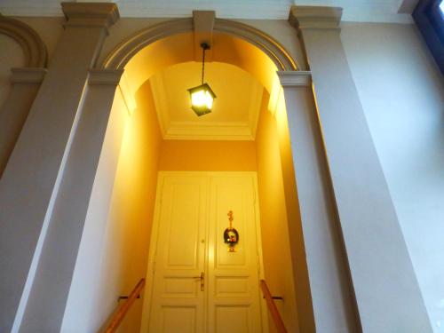 un corridoio con una porta bianca e una luce di Konzul a Osijek
