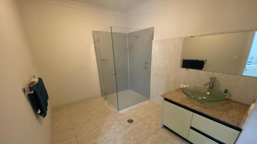 Unit 36 Seafront Estate في جوريين باي: حمام مع دش زجاجي ومغسلة