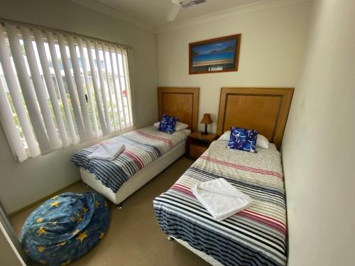 a bedroom with two beds and a ottoman at Unit 29 Seafront Estate in Jurien Bay