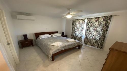 Un dormitorio con una cama y un ventilador de techo. en Miss Boronia, en Jurien Bay