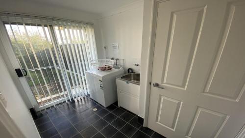 una pequeña cocina con fregadero y puerta en Miss Boronia, en Jurien Bay