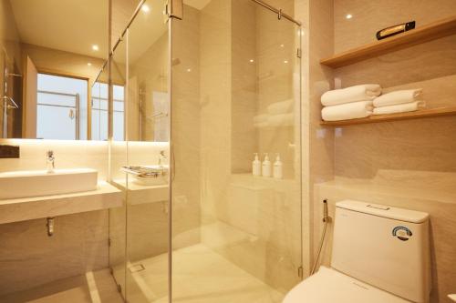 y baño con ducha, aseo y lavamanos. en HOTEL WISMA RATCHABURI, en Ratchaburi