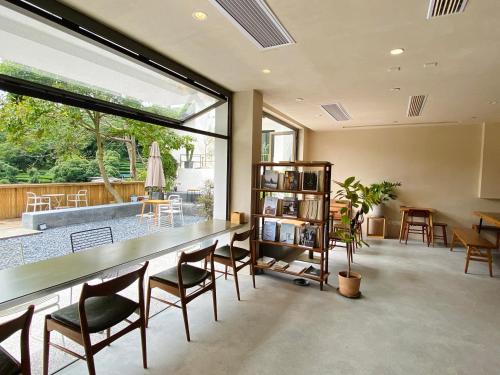 a living room with a table and chairs and a large window at Hangzhou Sansu Hotel in Hangzhou
