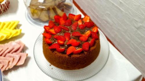 una tarta de chocolate con fresas en un plato sobre una mesa en Pousada Canto da Mata Ilhabela en Ilhabela