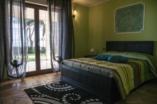 a bedroom with a bed and a large window at Casale delle Rose B&B Fattoria in Montepagano