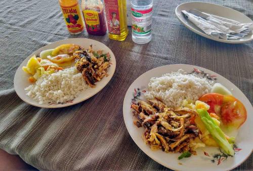 due piatti di cibo e riso su un tavolo di San Blas Islands - Private Cabin Over-the-Ocean + Meals + Island Tours a Mandinga