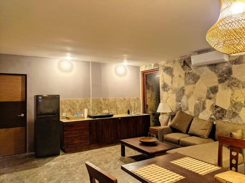a living room with a couch and a kitchen at Tanoma Sumba in Maujawa