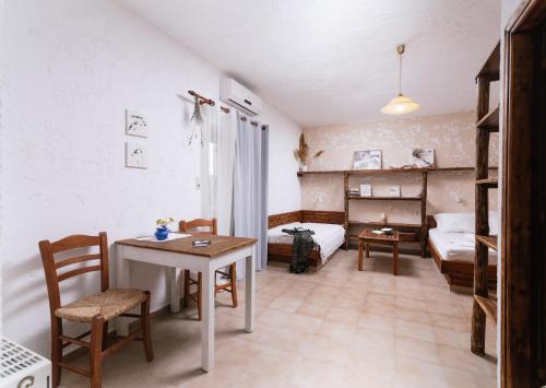 una piccola camera con tavolo e letto e una camera da letto di OVGORA - Ismini Sea View Room in Kamilari Village a Kamilari