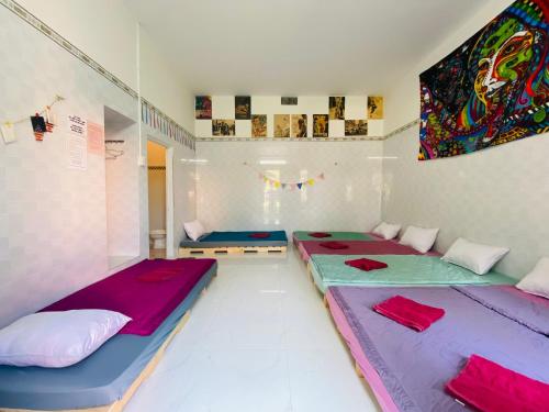 two beds in a room with purple and blue at Hồ Cốc Homestay in Ho Coc