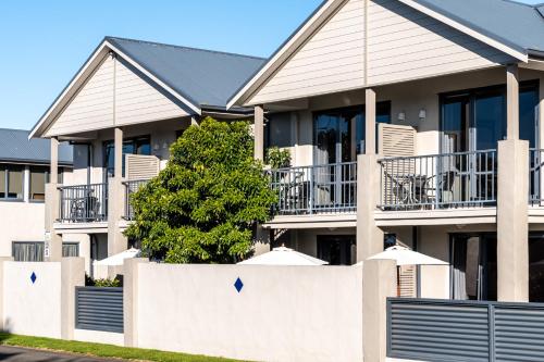 a white fence in front of a house at Nautilus Lodge Motel in Motueka