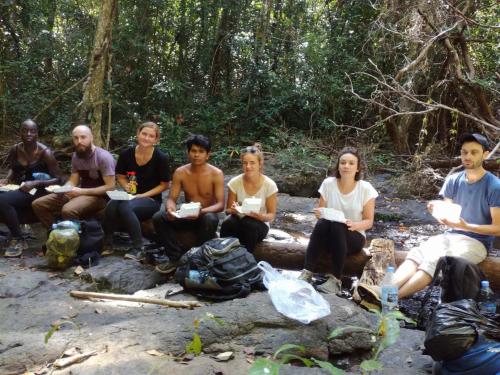 a group of people sitting around a campfire at Ratanakiri Farmhouse & Trekking in Banlung