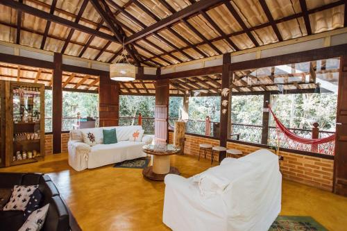 una sala de estar con muebles y ventanas blancos. en Pousada Canto da Mata Ilhabela en Ilhabela