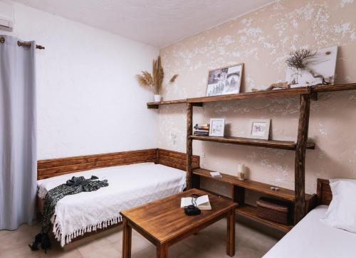 una camera con due letti, un tavolo e una mensola di OVGORA - Ismini Sea View Room in Kamilari Village a Kamilari