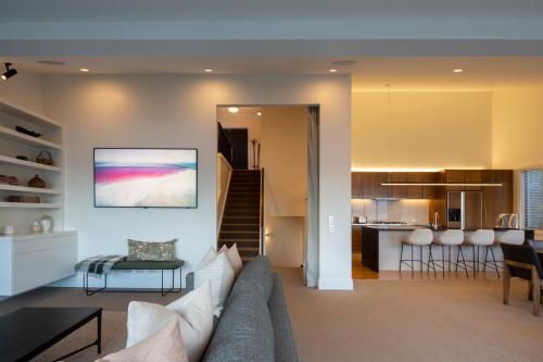 a living room and kitchen with a couch and a table at Picture Point Villa in Queenstown