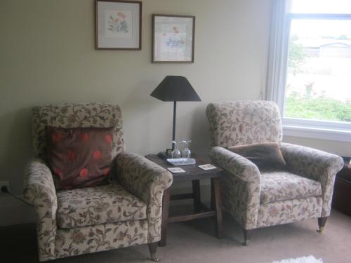 a living room with two chairs and a table at Anglesea House Inn in Renwick