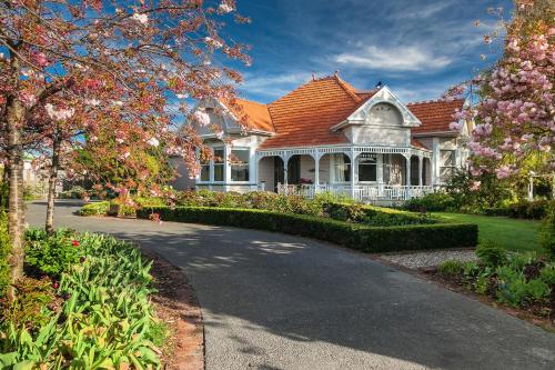 a white house with a red roof and a driveway at Anglesea House Inn in Renwick