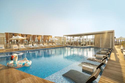 una gran piscina con sillas y un tobogán de agua en The House Hotel Al Khiran, en Al Khīrān