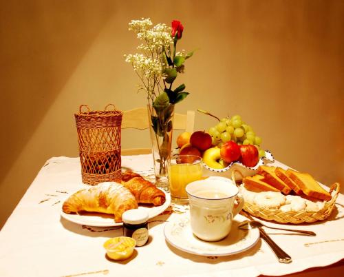 a table with a breakfast of croissants bread and fruit at Le Stanze dei Nonni in Avellino