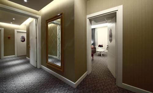 a hallway with a mirror and a room with a table at Montania Special Class Hotel in Mudanya