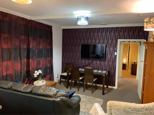 uma sala de estar com um sofá e uma sala de jantar em Bungalow on Centre em Invercargill