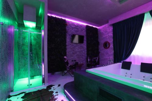 ein lila und grünes Bad mit einer Badewanne und einer Dusche in der Unterkunft Alcova Suite&Relax in Eboli