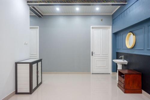 a bathroom with a sink and a blue wall at Urbanview Hotel Umbrella Dieng by RedDoorz in Kalibeber