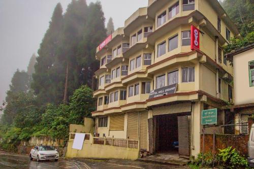 a building with a car parked in front of it at OYO Hill Grand Himalaya in Darjeeling