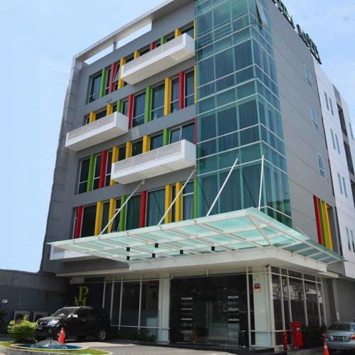 een gebouw met kleurrijke ramen en een auto voor de deur bij Putra Mulia Hotel Medan in Medan