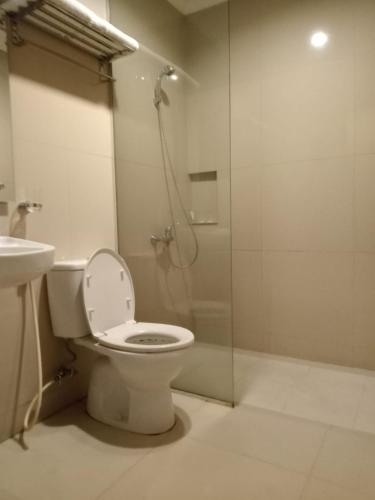 een badkamer met een douche, een toilet en een wastafel bij Putra Mulia Hotel Medan in Medan