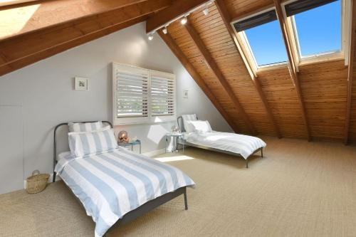 a attic bedroom with a bed and a window at Alleura House in Leura