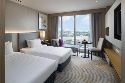 バンコクにあるAsawin Grand Convention Hotelのベッド2台とテレビが備わるホテルルームです。