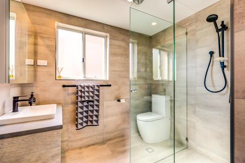 a bathroom with a shower and a toilet and a sink at Boutique by Jervis Bay by Experience Jervis Bay in Vincentia