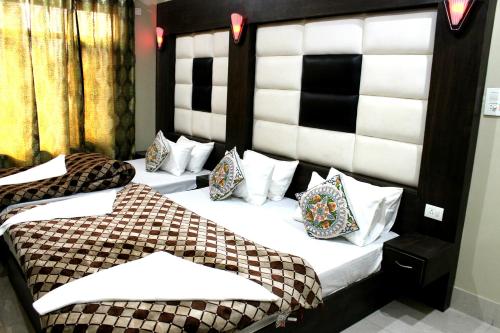two beds in a hotel room with a headboard at Hotel Samar in Srinagar