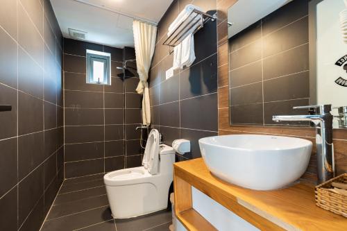 a bathroom with a white sink and a toilet at Smeraldo Hotel & Apartment in Da Nang