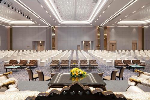 a large banquet hall with tables and chairs at Asawin Grand Convention Hotel in Bangkok