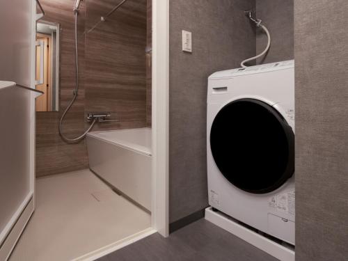 a bathroom with a washing machine and a shower at MIMARU SUITES Tokyo NIHOMBASHI in Tokyo