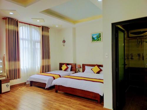 1 dormitorio con 2 camas y ventana en NHÀ GÓC PHỐ Đà Lạt, en Da Lat